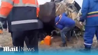 Rescuers crawl into the wreckage of the Azerbaijan plane crash