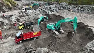 excavators work digging sand, dump trucks transport sand