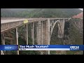 overtourism is killing big sur banner appears on iconic bixby bridge