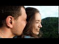 A young woman smiles happily in the arms of her boyfriend.