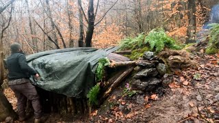 冬季高山露营，大石头下搭建带壁炉的丛林小屋苔藓和木墙野外生存