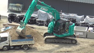 Japanese hydraulic excavators load earth into a dump truck. July 20, 2023.