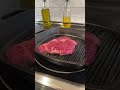 10oz angus ribeye steak on cast iron with coconut oil seasoned with salt and pepper