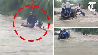 Watch a group of villagers in Gujarat's Rajkot come to rescue of a scooterist stuck in flood waters