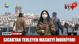 Sıcaktan terleyen maskeyi indiriyor!