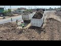 Enormous being extracted from construction site using expertise of SHANTUI SD22 bulldozer load truck