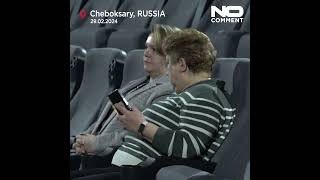 People watch Russian President Vladimir Putin's state of nation address in cinema