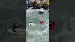 HEROIC moment surfer RESCUES fisherman who fell into sea