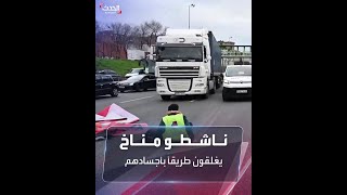 ناشطو مناخ يغلقون طريقاً سريعاً في مدريد.. وسائقون يجرونهم بالقوة