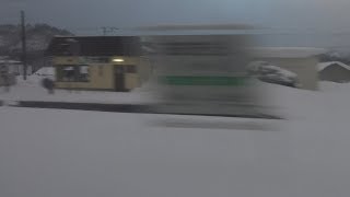 深い雪に覆われた厳寒の大岸駅を通過する室蘭本線上り特急スーパー北斗キハ281系の車窓