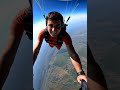 describe someone skydiving experiencing high speeds and strong winds along with dramatic views