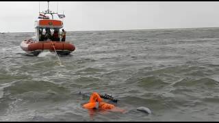 Omgeslagen zeiljacht wordt naar het strand gesleept