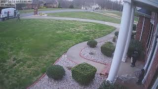 Two FedEx drivers drop a package in front of the driveway.