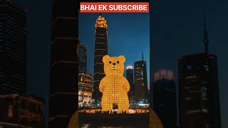 a giant yellow gummy bear, 4 stories tall, shanghai bund at night