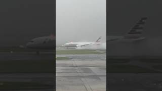 雨の中水しぶきを上げながら羽田空港に着陸する飛行機