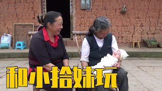 黄小妹和六嫂坐在院子里陪小拾妹玩，幺叔用竹丫枝扎扫把【幺妈和幺叔】