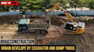 (DRONE CAPTURE) CAT EXCAVATOR 320D WORKING ON SITE WITH MULTIPLE DUMP TRUCKS