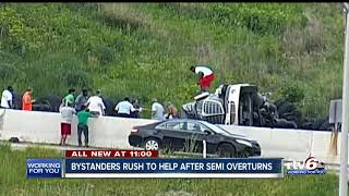 Bystanders rush to help after semi overturns