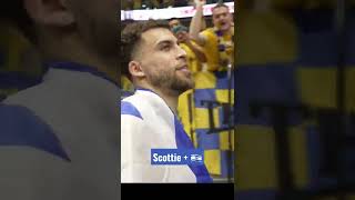 Scottie Wilbekin greets the Maccabi fans while covered in the Israel flag