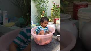 a small boy is bathing in tub