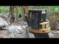 mini excavators swinging dirt breaking the rocks for the narrow road widening construction