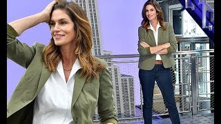 Cindy Crawford looks her model best in jeans and a blazer as she lights The Empire State Building bl