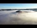 flying over hills in mystic foggy winter morning. aerial view by drone