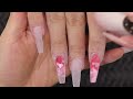 uÑas con corazones encapsulados mano alzada clienta san valentín