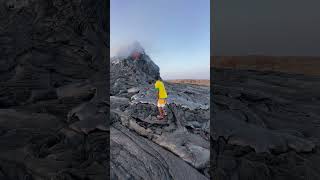 Traveler pokes molten lava as Erta Ale volcano erupts in Afar, Ethiopia