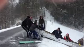 Canoe Slides Down Snowy Hill into Lake