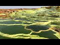 danakil depression salt flats hillside of clear green sulfur pools