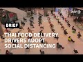 Thai food delivery drivers adopt social distancing | AFP