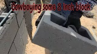 Laying some 8 inch block on a retaining wall