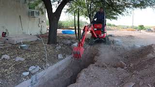 kubota u10-5 digging out and remove a block wall footing to install a water line for the shop