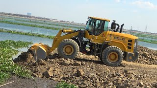 Extreme SDLG Wheel Loader With Dump Truck Spreading Gravel Rock On Road