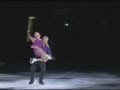 Torvill and Dean skate holding the Olympic torch in Nottingham