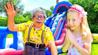 Nastya joue sur le trampoline et s'amuse avec son grand-père