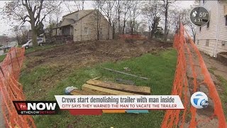 Crews start demolishing trailer with man inside