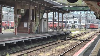 米子駅の車両基地に多数停泊している朱色のキハ40系とホームに停車中のキハ126系