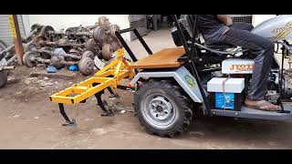 The cultivator is mounted on the back of a three-wheeled tractor,JYOTI THREE WHEELER TRACTOR,