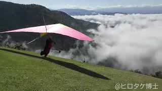 絶景、雲海のような霧に向かって飛び立つハングライダー。