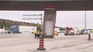 Dump truck stuck upright under Highway 401 bridge in Mississauga