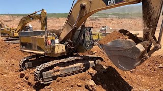 Three Caterpillar 365C Excavators And Caterpillar 245B Loading Trucks In A Row