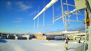 Timelapse rooftop camera video, blue clear or cloudy winter skies and snow, antenna array, Finland