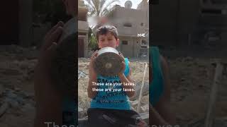 Palestinian child holds up US-made munition in Gaza