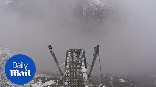 Wing-suited man dives into abyss through foggy Swiss valley