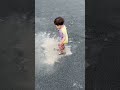 水たまりで豪快に遊ぶ1歳児