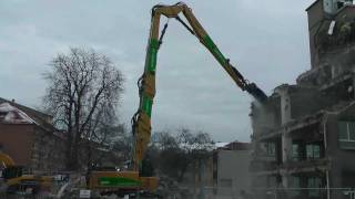 Cat DEM70 High Reach Demolishing a building