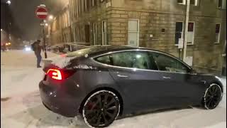 'You can't park there sir!' Tesla slides down the road in heavy snow