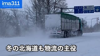 雪道となった北海道の国道を走るトレーラー・トラック